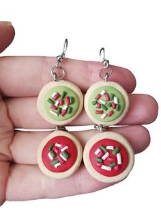 the earrings are decorated with candy canes and sprinkles in green, red, and white