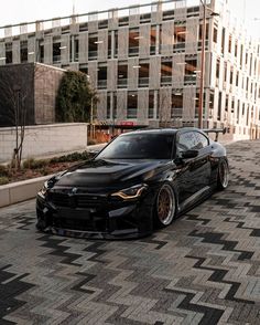 a black car parked in front of a tall building