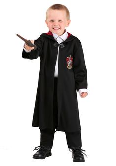 a young boy dressed in a harry potter costume holding a wand and pointing at the camera