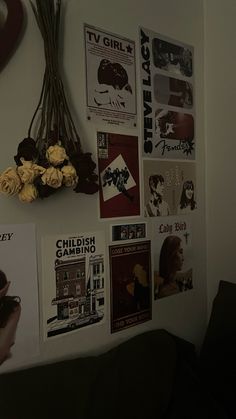 a wall with posters and flowers on it