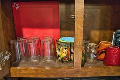 an open cabinet filled with glasses and other items