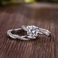 a diamond ring on top of a wooden table with diamonds in the band and center stone