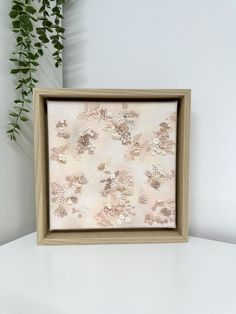 a wooden frame with flowers on it sitting next to a potted plant in the corner