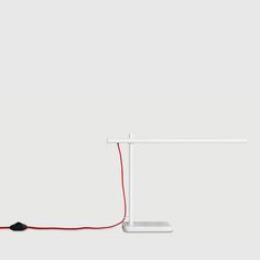 a white desk lamp with a red cord connected to it