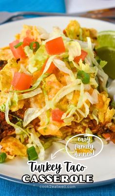 a white plate topped with taco casserole covered in lettuce and tomatoes