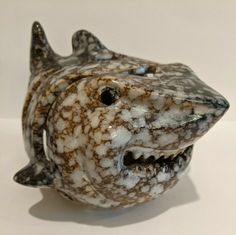 a ceramic fish with its mouth open on a table