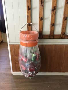 a plastic bag filled with candy sitting on top of a wooden floor next to a wall