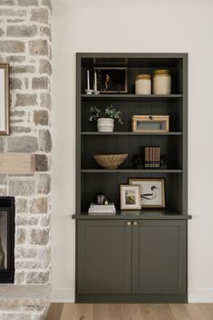 a living room with a fireplace and bookcase