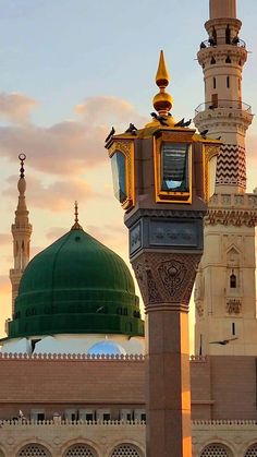 a tall tower with a clock on it's side next to a green dome