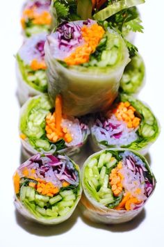 several rolls filled with veggies and carrots on top of each other,