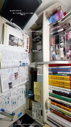 the inside of an office cubicle with many books and magazines stacked on top of each other