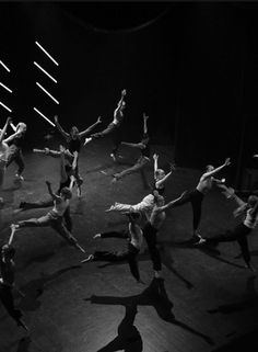 a group of people standing on top of a stage with their arms in the air