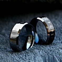 two wedding rings with roman numerals on them sitting on a blue carpeted surface