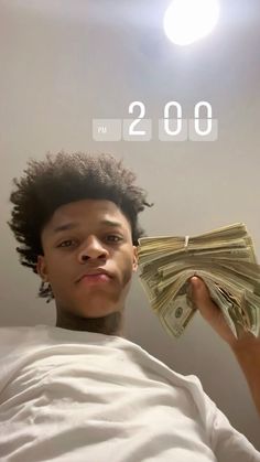 a young man holding money in front of his face with the time 2 00 on it