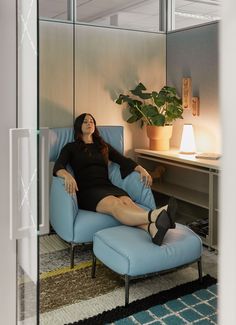 a woman sitting in a blue chair with her legs crossed