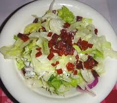 a salad with strawberries and lettuce is on a white plate, ready to be eaten