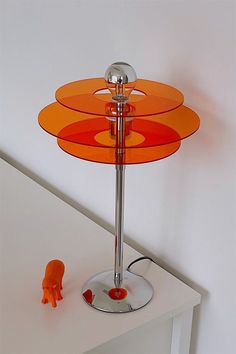 an orange table lamp sitting on top of a white counter