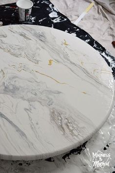 a marble table top being painted white and gold