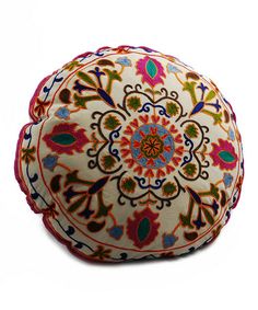 a colorfully decorated round pillow sitting on top of a white surface