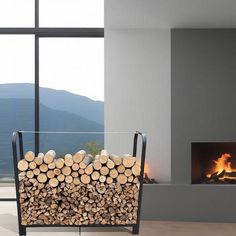 a fire place with logs stacked in front of it and a large window behind it