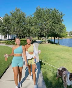 two women walking their dog on a leash