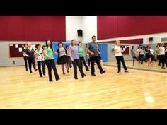 a group of people standing on top of a wooden floor next to each other in a gym