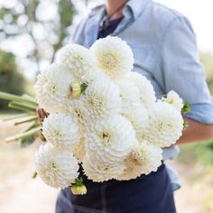 a man holding a bouquet of white flowers