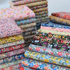 a pile of colorful fabric sitting on top of a white table next to each other