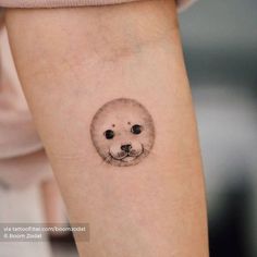 a small seal bear tattoo on the left inner arm