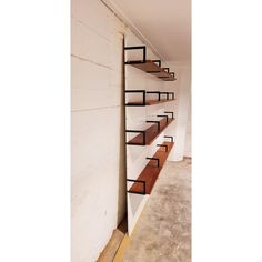 an empty room with some shelves on the wall and stairs in front of it that are made out of plywood