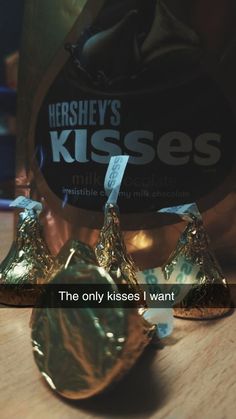 hershey's kisses are on the table next to some foil wrapped chocolates