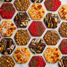 assorted chocolates and nuts arranged in hexagonal shapes on a white surface