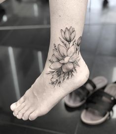 a woman's foot with a flower tattoo on it