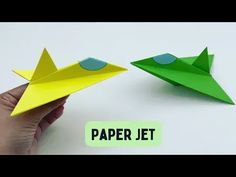 a hand holding an origami paper jet and another hand holding a paper airplane