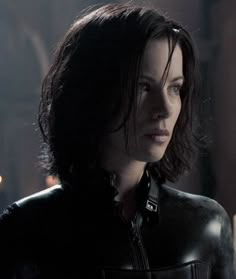 a woman in black leather jacket looking off into the distance