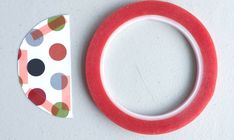 a pair of red tape next to a polka dot washi tape on a white surface