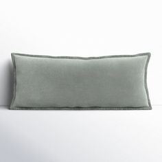 a gray pillow sitting on top of a white wall