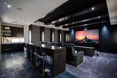 a home theater with chairs and a large screen