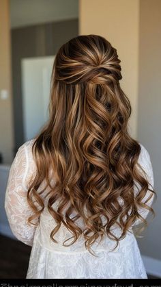 the back of a woman's head with long wavy hair in half - up style