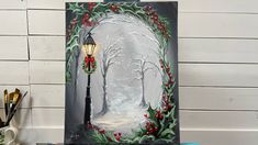 a painting of a street light with holly wreaths on it, next to other items