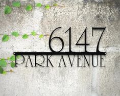 the address sign for 617 park avenue is displayed on a concrete wall with green leaves