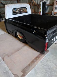 an old black pickup truck parked in a garage