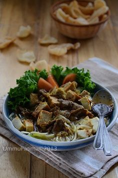 a bowl filled with meat and vegetables on top of a table