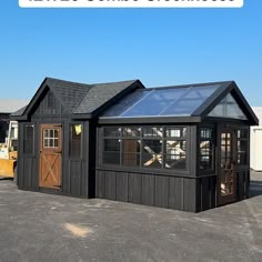 a small black building with a glass roof