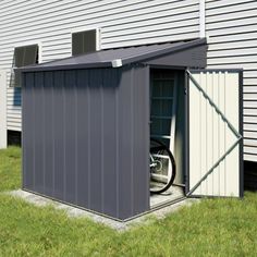 an outdoor storage shed with the door open and wheels on it's side in front of a building