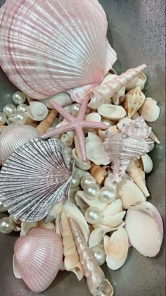 seashells and pearls in a bowl on the beach