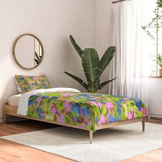 a bedroom with a bed, mirror and plant in the corner on the wall next to it