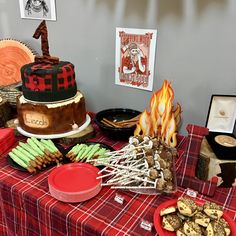 a table topped with cakes and desserts on top of a red checkered table cloth