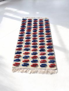 a red, white and blue rug is laying on the floor