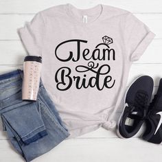 a t - shirt that says team bride with a diamond on it and some jeans